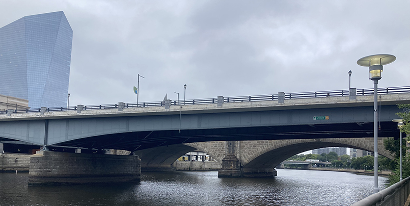 Image of the JFK Boulevard Bridge from the south on an overcast day, with a lit up lamp in the foreground