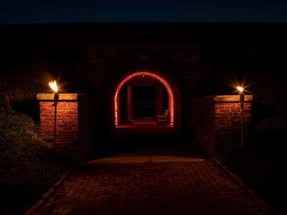 Image of Fort Mifflin eerily lit up by orange lights
