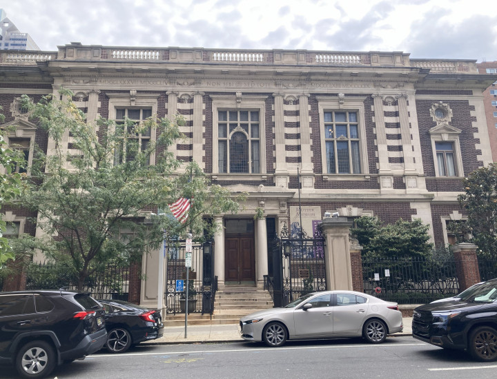 Entrance to the Mutter Museum on an overcast day, with cars driving down the street in front of the musem